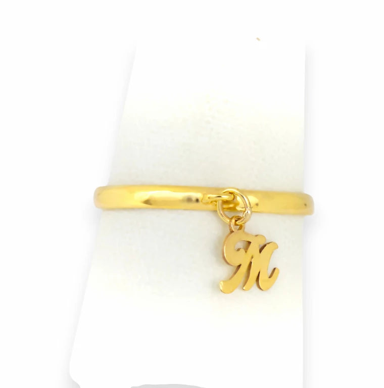 Small script initial M charm dangle ring, personalized custom real gold band on white display, dainty stackable style.