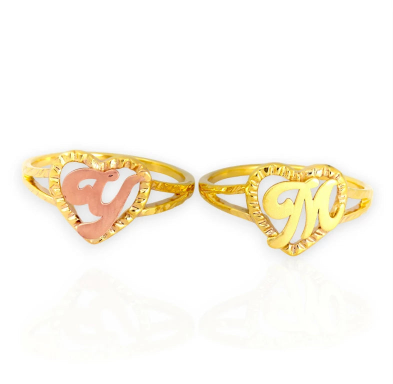 Two gold rings with 'V' and 'M' designs on a white background